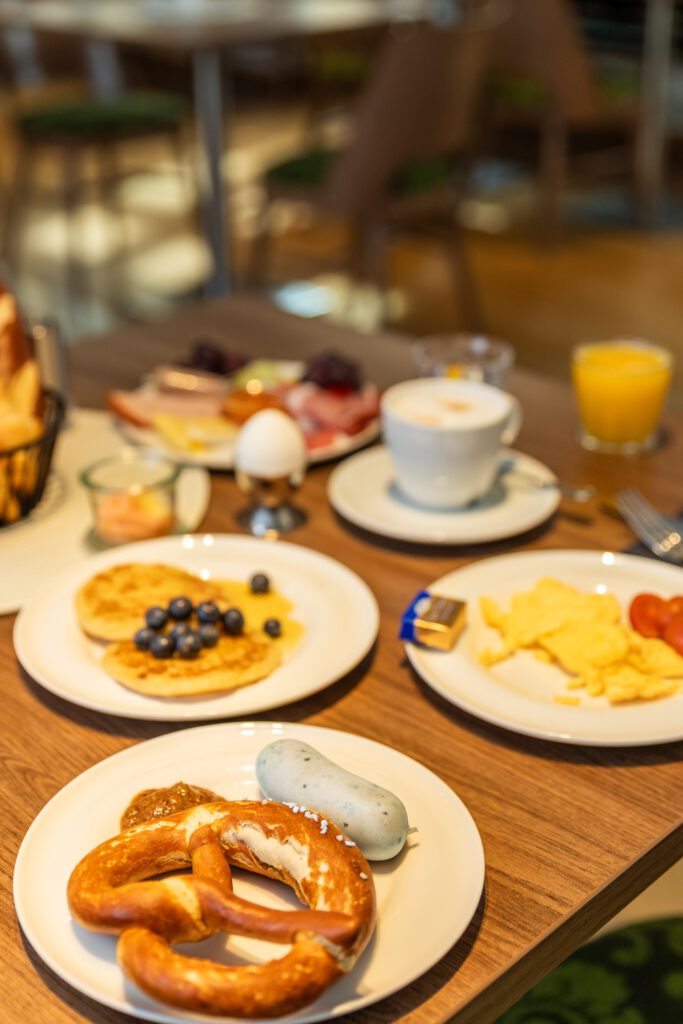 Frühstück auf dem Tisch mit Weißwurst, Breze und Pfannkuchen